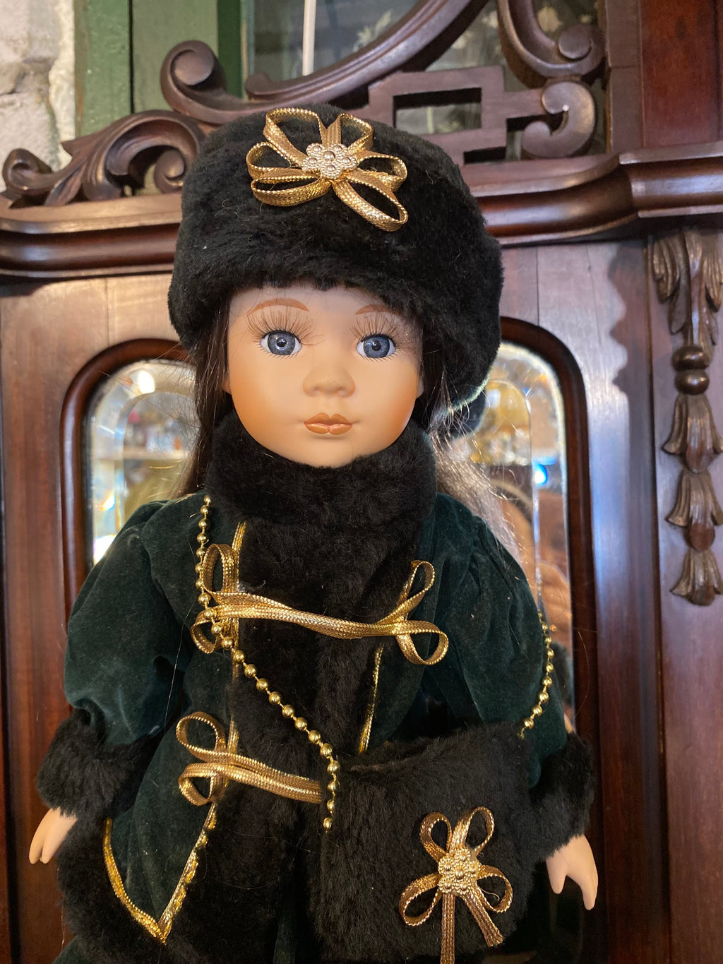 Vintage porcelain doll with elegant winter clothing