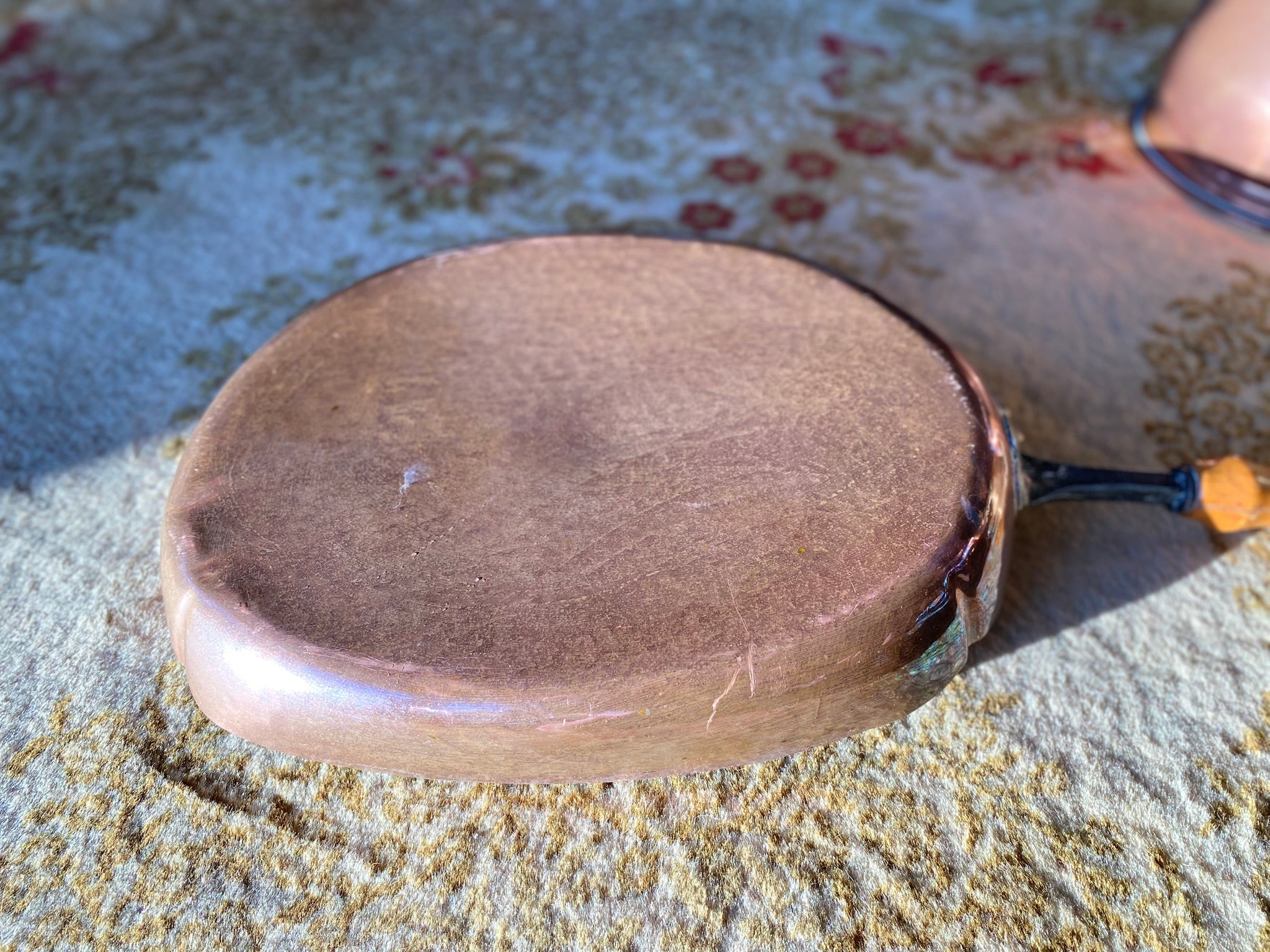 Old oval copper pan with wooden handle