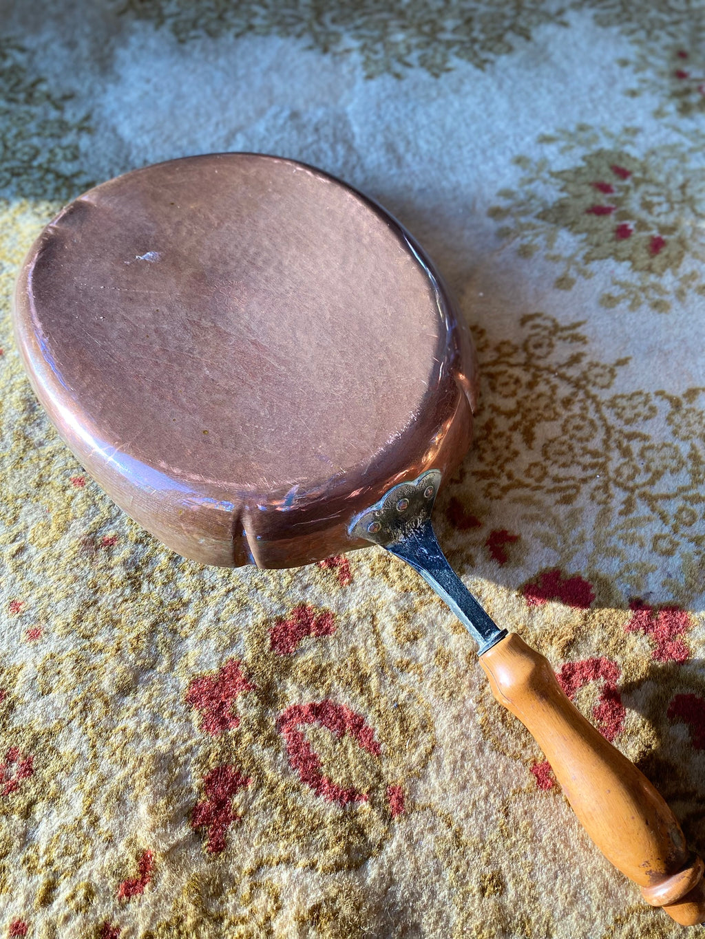 Old oval copper pan with wooden handle