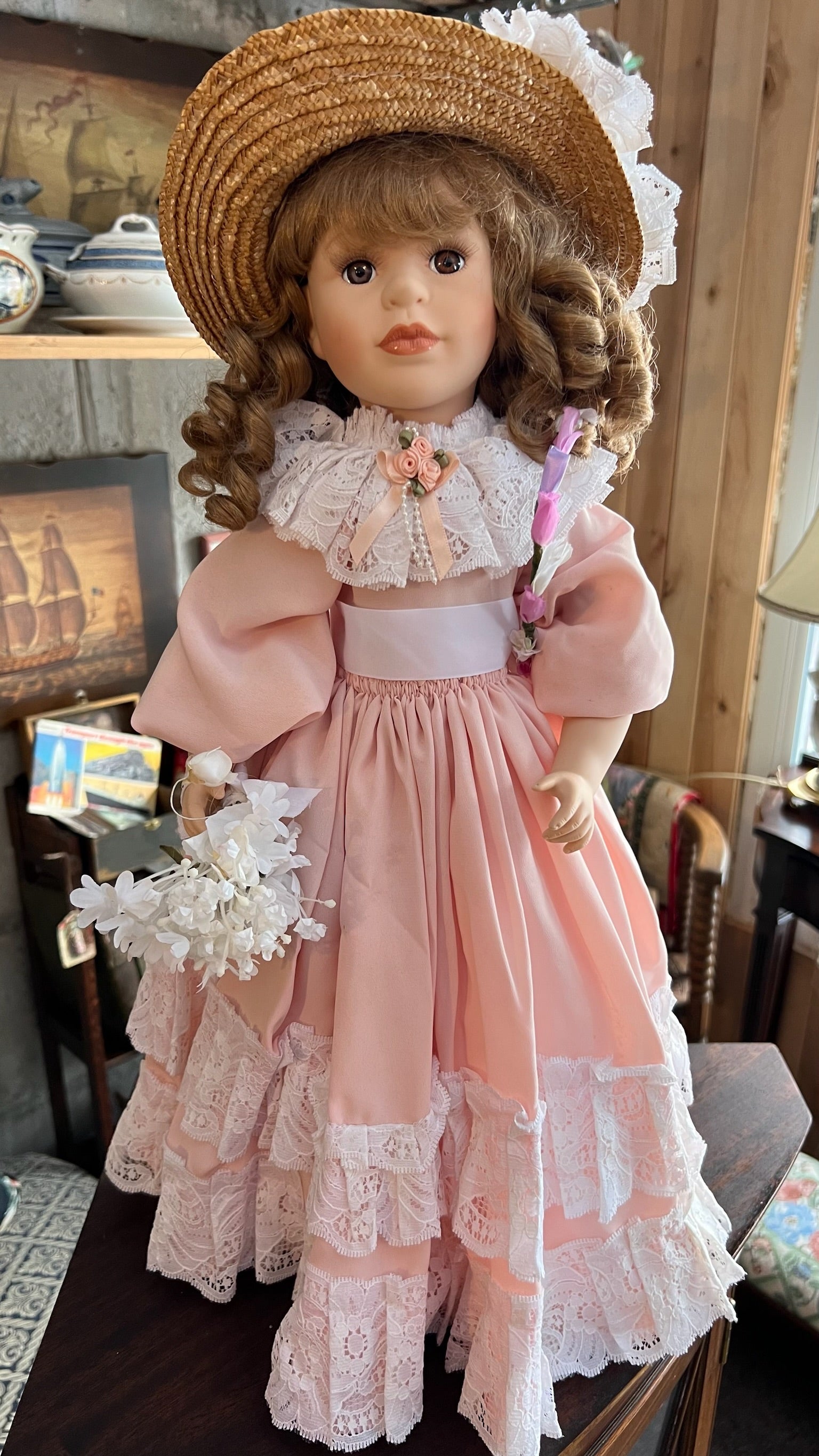 Porcelain collectible doll in a pink lace dress