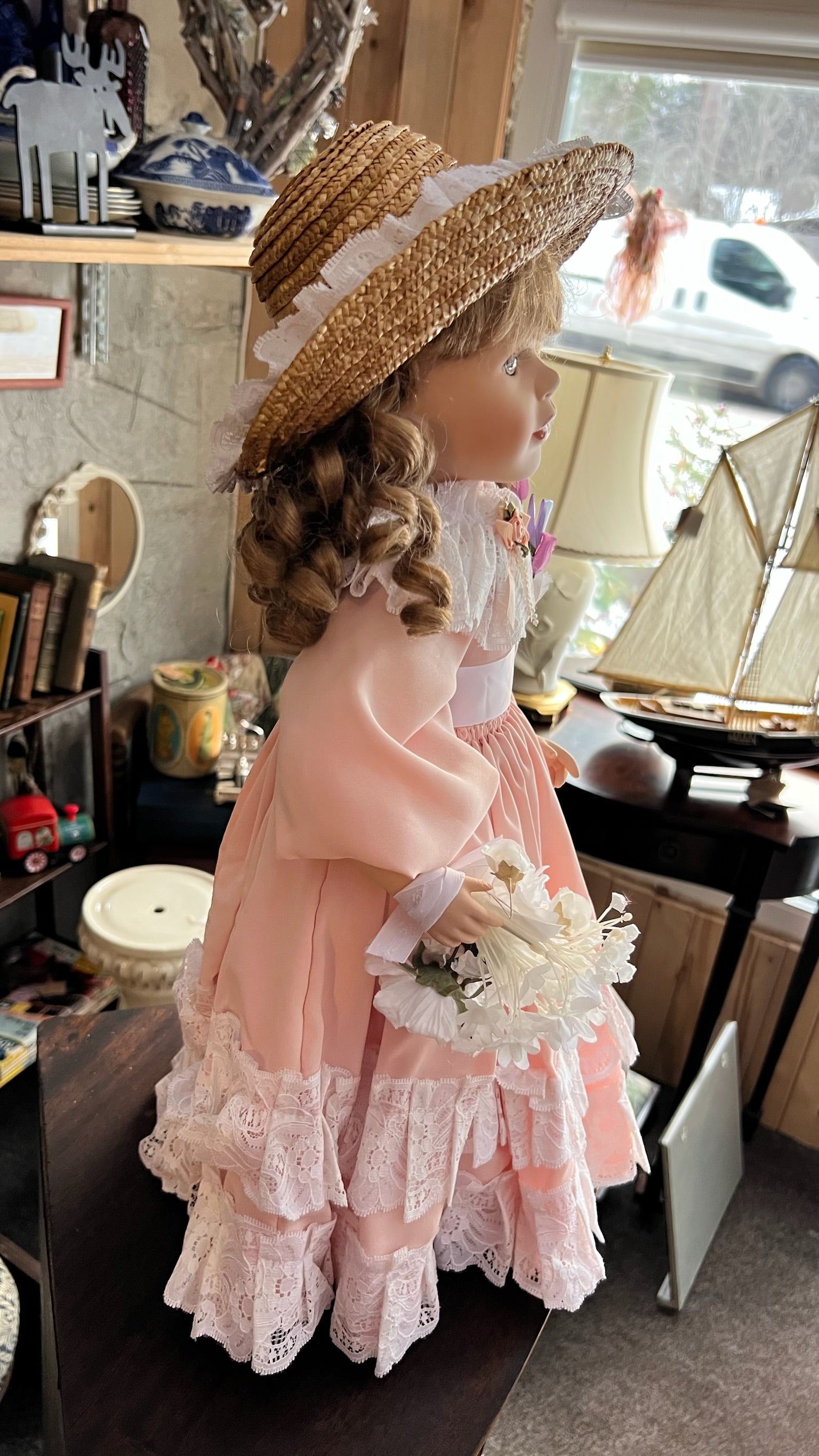 Porcelain collectible doll in a pink lace dress