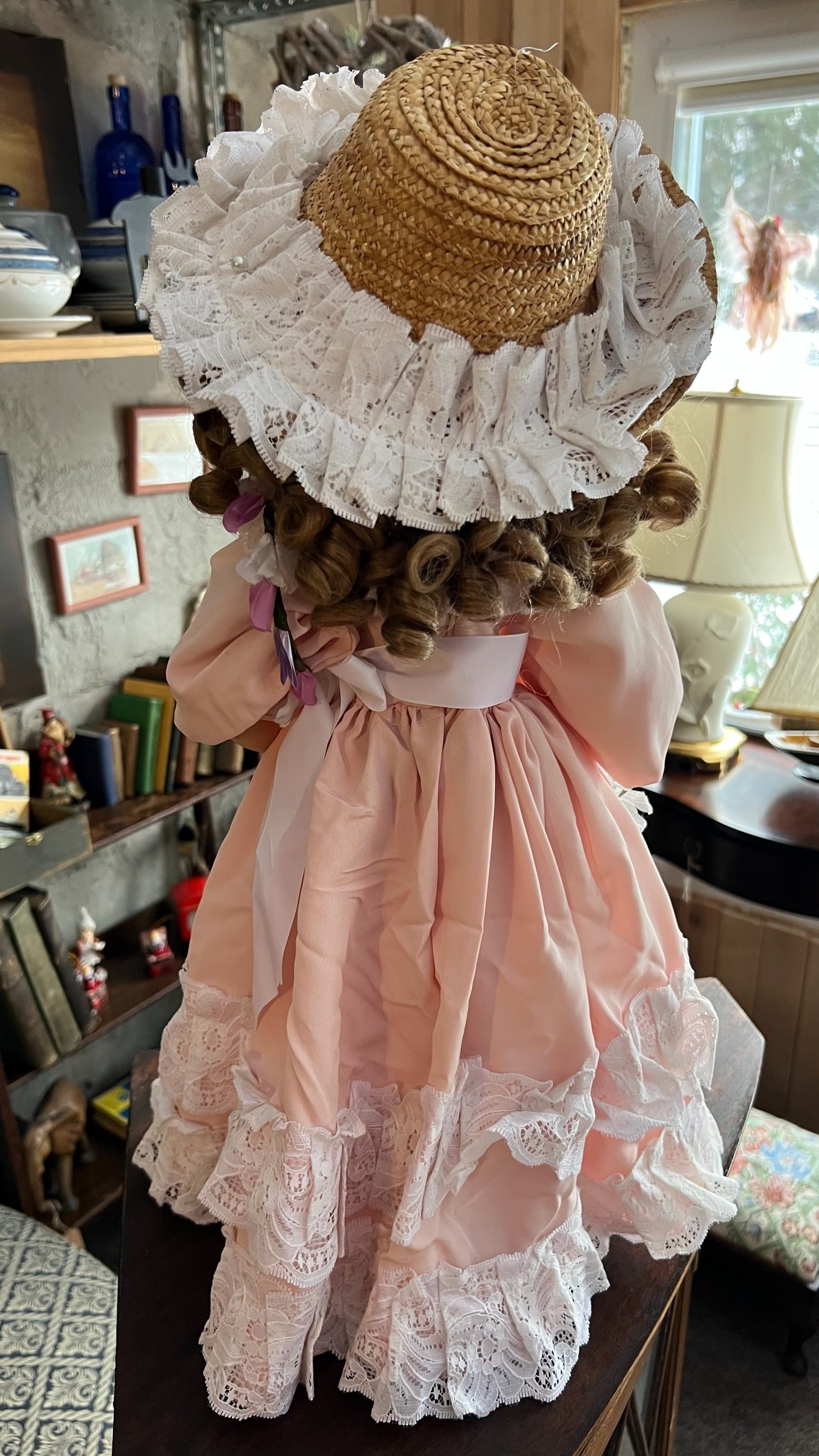 Porcelain collectible doll in a pink lace dress